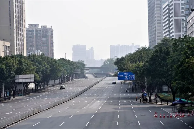 Few cars are seen on the empty street in the recently locked down Haizhu district in Guangzhou in southern China's Guangdong province Friday, November 11, 2022. As the country reported 10,729 new COVID cases on Friday, more than 5 million people were under lockdown in the southern manufacturing hub Guangzhou and the western megacity Chongqing. (Photo by AP Photo/Stringer)