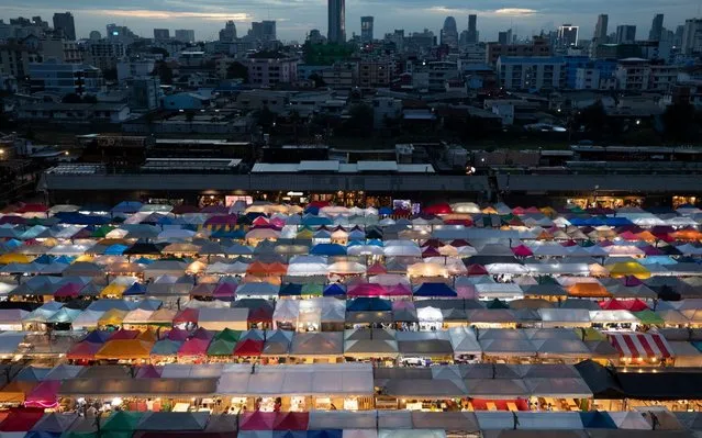 Tents of food stalls and other vendors are illuminated at Rot Fai Market in Bangkok, Thailand, Friday, June 19, 2020. Daily life in the capital resumes to normal as the government continues to ease restrictions related to running business and activities that were imposed weeks ago to combat the spread of COVID-19. Thailand reported no local transmissions of the coronavirus in the past 3 weeks. (Photo by Sakchai Lalit/AP Photo)