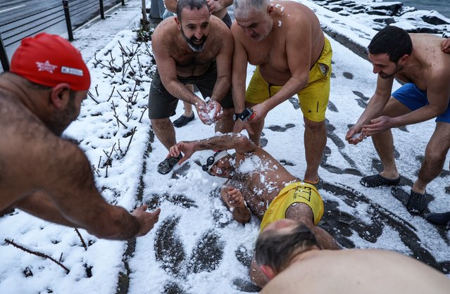 Members of the “Conquerors of Sarayburnu” play around in the snow before their daily routine of swimming in the Bosphorus' cold waters during a rainy 1-degree Celsius morning in Istanbul, Turkey, 21 February 2025. (Photo by Erdem Sahin/EPA/EFE)