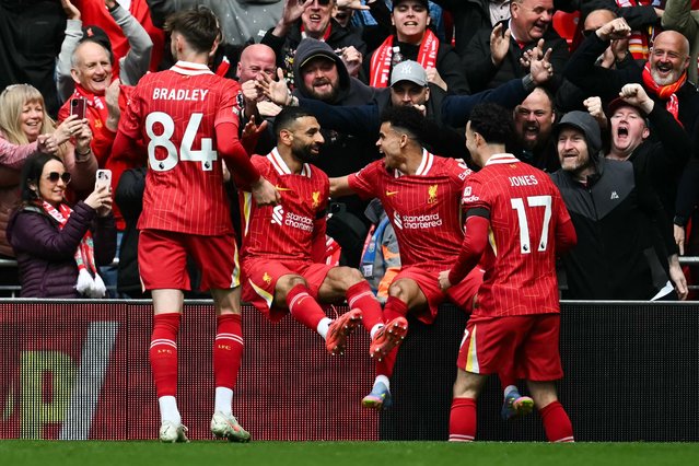 Liverpool's Colombian midfielder #07 Luis Diaz (2nd R) celebrates with Liverpool's English midfielder #17 Curtis Jones (R), Liverpool's Egyptian striker #11 Mohamed Salah and Liverpool's Northern Irish defender #84 Conor Bradley after scoring his team first goal during the English Premier League football match between Liverpool and West Ham United at Anfield in Liverpool, north west England on April 13, 2025. (Photo by Paul Ellis/AFP Photo)