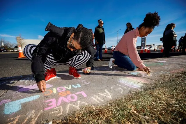 Latisha Hardy (L) and daughter Yvonne Shepherd (R) write notes in chalk on the sidewalk at a memorial site for victims after the mass shooting at LGBTQ nightclub Club Q in Colorado Springs, Colorado, U.S. November 22, 2022. (Photo by Isaiah J. Downing/Reuters)