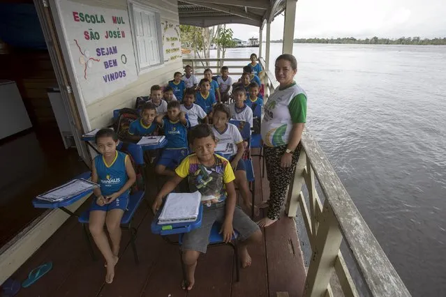 Children of the floating Municipal School Sao Jose II pose for a picture along the Amazonas River bank in a rural area of Manaus, Brazil, June 18, 2015. (Photo by Bruno Kelly/Reuters)