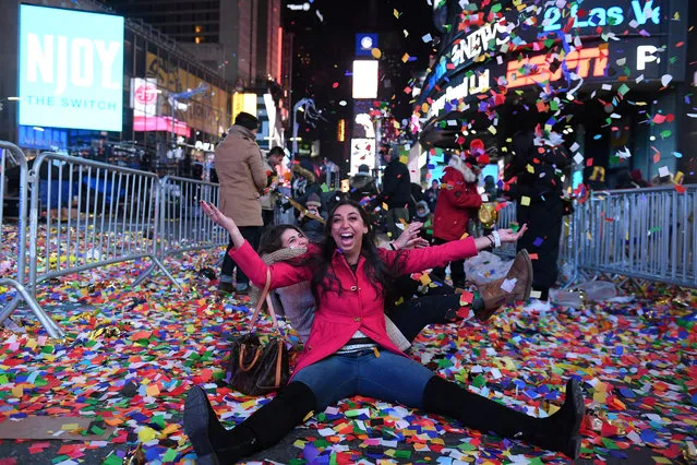 Revelers play in confetti in Times Square during New Year celebrations in Manhattan, New York on January 1, 2018. (Photo by Darren Ornitz/Reuters)
