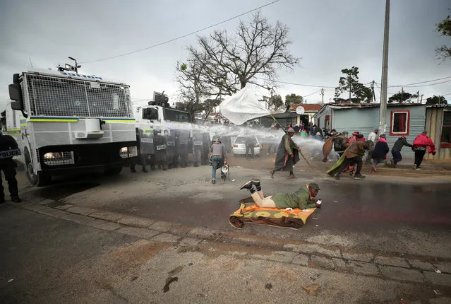 Police use a water cannon to disperse demonstrators protesting against racial and economic inequalities in Kayamandi township near Stellenbosch, South Africa, August 12, 2020. (Photo by Mike Hutchings/Reuters)