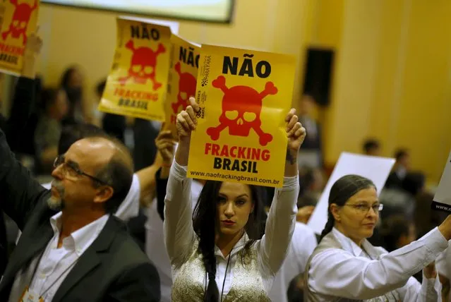 Anti-fracking demonstrators hold signs during an auction of oil and natural gas exploration rights, in Rio de Janeiro, Brazil, October 7, 2015. As Brazil prepares for its first sale of oil exploration rights in nearly two years on Wednesday, the auction is shaping up to be a mini-referendum on the willingness of investors to bet on the future of an industry under pressure and a Brazilian economy in turmoil. The signs reads, "No Fracking Brazil". (Photo by Pichi Chuang/Reuters)