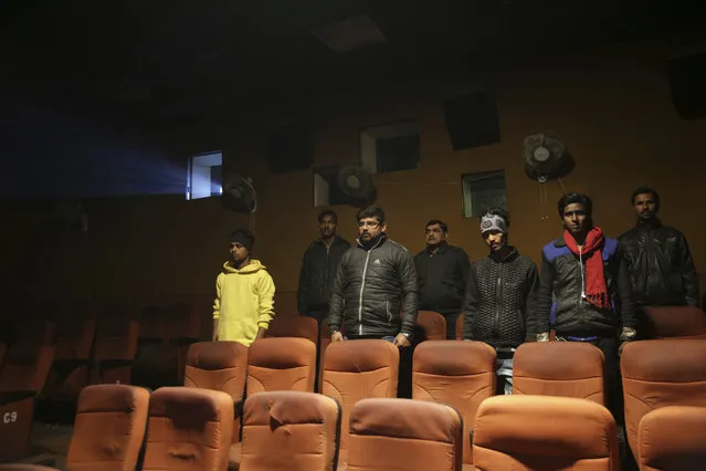Indian moviegoers stand up as national anthem is played at a cinema  before the screening of a movie in Allahabad, India, Tuesday, January 9, 2018. India's Supreme Court on Tuesday reversed a ruling that ordered the national anthem to be played before movie screenings while audiences stand, a ruling that sparked a spate of arrests and attacks on cinema-goers who refused to rise. (Photo by Rajesh Kumar Singh/AP Photo)