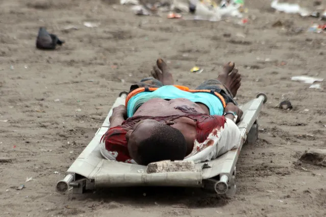 The body of a man killed during election protests lies in the street, in Kinshasa, Democratic Republic of Congo, Monday, September 19, 2016. (Photo by John Bompengo/AP Photo)