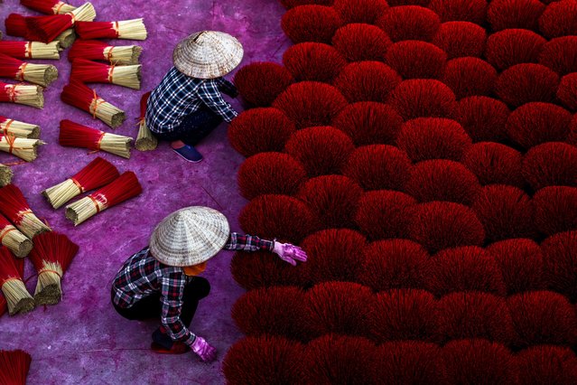 Workers arrange incense sticks to be dried in a courtyard ahead of the Lunar New Year celebrations in Quang Phu Cau village, outside Hanoi, Vietnam, on January 20, 2025. (Photo by Athit Perawongmetha/Reuters)