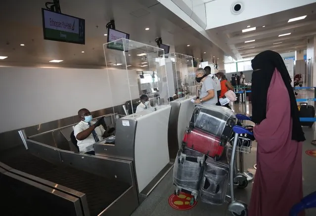 Ticketing officials attends to passengers inside the departure terminal of the Nnamdi Azikiwe International Airport, in Abuja, Nigeria on September 7, 2020. After a five-month closure of the Nigerian airspace due to the COVID-19 coronavirus pandemic, flight resumptions began in Abuja, Nigeria. (Photo by Kola Sulaimon/AFP Photo)