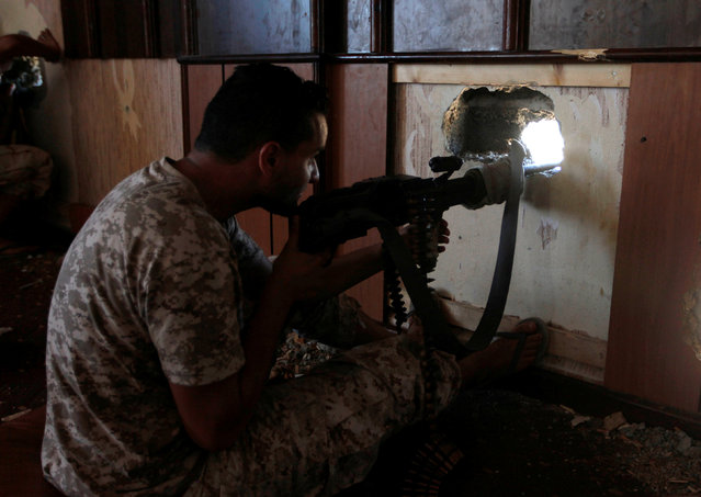 A fighter from Libyan forces allied with the U.N.-backed government aims his weapon as he takes position in building during a battle with Islamic State militants in Sirte, Libya September 24, 2016. (Photo by Ismail Zitouny/Reuters)