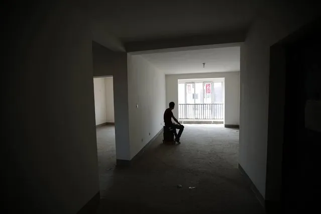 Zhiliang, whose fiancee was onboard Malaysia Airlines Flight MH370 which disappeared on March 8, 2014, is silhouetted at an empty house which he had planned to decorate with her for their marriage, in Tianjin, in this August 26, 2014 file photo. Almost six months had passed since the Malaysian Airlines MH370 disappeared. Although authorities concluded that the plane crashed in the remote Indian Ocean and lost all the passengers, many family members refuse to accept that conclusion. (Photo and caption by Kim Kyung Hoon/Reuters)