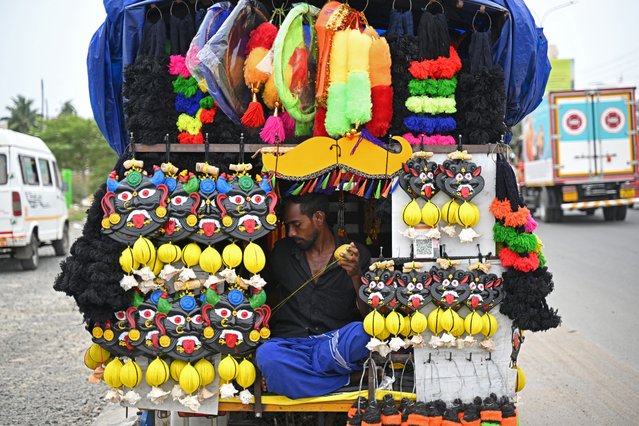 A man prepares demon masks usually put on display at homes with the belief to ward off evil spirits, in Chennai on July 2, 2025. (Photo by R. Satish Babu/AFP Photo)