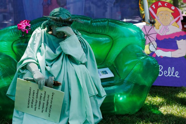 A woman dressed as the Statue of Liberty sits on an inflatable couch during the “Rage Against The Regime” rally in Cambridge, Massachusetts, USA, 02 August 2025. The rally is part of a larger protest happening on the day across the country. (Photo by CJ Gunther/EPA)