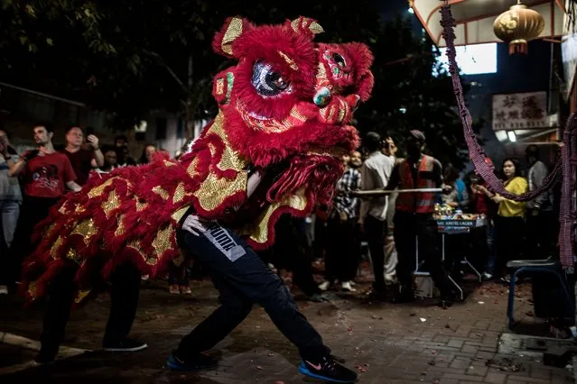 Dancers perform the lion dance to bless each store during celebrations marking the Chinese New Year, the Year of the Dog, in First Chinatown, Johannesburg, South Africa on February 24, 2018. (Photo by Gulshan Khan/AFP Photo)