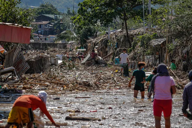 Residents salvage their belongings along a road covered in mud and debris following typhoon Vamco in Rodriguez, Rizal, east of Manila, Philippines, 13 November 2020. (Photo by Mark R. Cristino/EPA/EFE)
