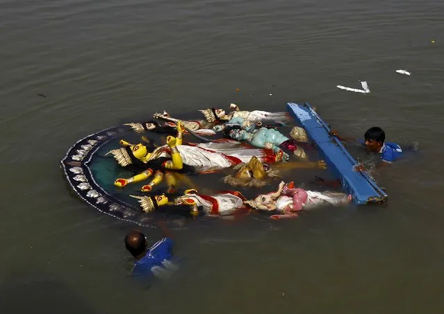 Municipal workers push an idol of the Hindu goddess Durga after it was immersed into the Ganges river after the end of the Durga Puja festival in Kolkata, India, October 25, 2015. (Photo by Rupak De Chowdhuri/Reuters)
