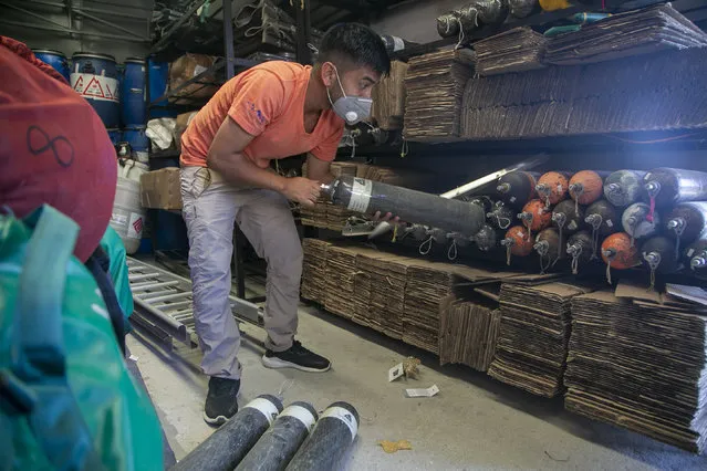 A Nepalese mountain guide plies up oxygen cylinders at the Seven Summit trekking agency in Kathmandu,  Nepal, Monday, November 2, 2020. Nepal has reopened its peaks and trails for foreign adventurers in hopes of providing much needed income for hundreds of thousands of guides, porters and workers who have been unemployed for months because of the pandemic. (Photo by Niranjan Shrestha/AP Photo)