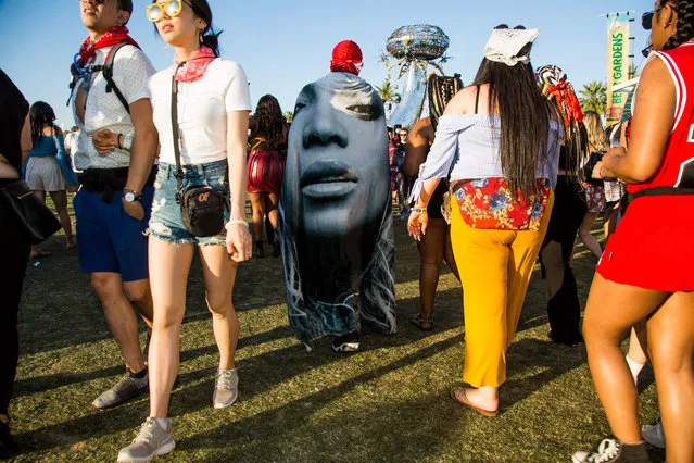 A fan walks through the festival grounds with a Beyonce cloth draped over during the Coachella Music and Arts Festival in Indio, California, April 14, 2018. (Photo by Kyle Grillot/AFP Photo)