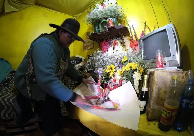 A female Aymara witchdoctor prepares an offering at the witches market of El Alto, on the outskirts of La Paz, December 31, 2014. (Photo by David Mercado/Reuters)