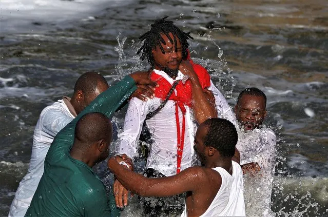 Members of the Morian African Church baptize Siboniso Mdaka in Kliprivier river, during a religious ceremony to celebrate Good Friday, in Katlehong, south-east of Johannesburg, South Africa on April 7, 2023. (Photo by Siphiwe Sibeko/Reuters)