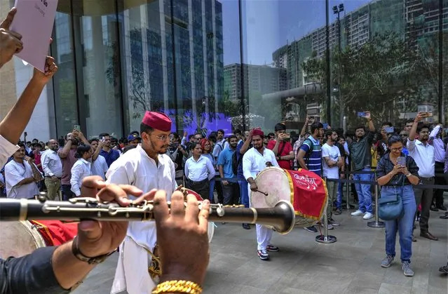 Artists play music as people wait in a queue during the opening of the first Apple Inc. flagship store in Mumbai, India, Tuesday, April 18, 2023. Apple Inc. opened its first flagship store in India in a much-anticipated launch Tuesday that highlights the company’s growing aspirations to expand in the country it also hopes to turn into a potential manufacturing hub. (Photo by Rafiq Maqbool/AP Photo)