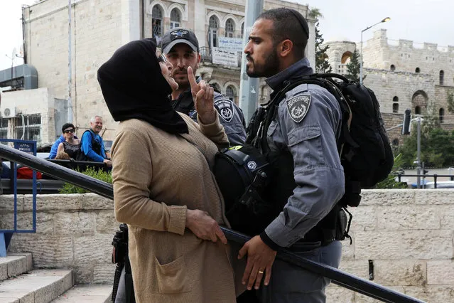 An Israeli police officer argues with a Palestinian woman outside Jerusalem's Old City's Damascus Gate, May 13, 2018. (Photo by Ammar Awad/Reuters)