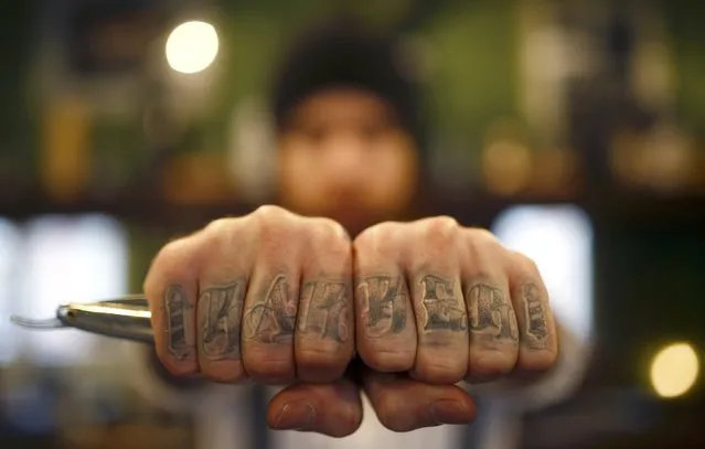 Alex “Torreto” Vellios, a 26-year old barber displays his tattoo reading "barber" as he waits for his first customer of the day at his Torreto barber shop in Frankfurt January 6, 2015. (Photo by Kai Pfaffenbach/Reuters)