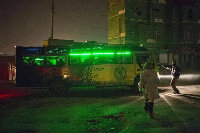 Men try to stop a public minibus in the early hours of the morning in Dandora, Nairobi, Kenya, June 14, 2015. (Photo by Siegfried Modola/Reuters)