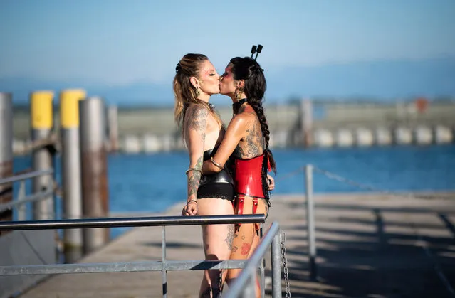 Costumed participants of a lacquer and leather ship, the so-called “Torture Ship”, kiss before putting out to Lake Constance for a pleasure cruise at the harbor of Friedrichshafen, Germany, 29 June 2019. Hundreds of leather and rubber fans set sail for the boat trip through the night on Lake Constance. (Photo by Daniel Kopatsch/EPA/EFE)