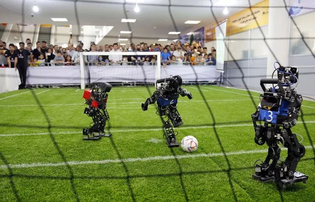 A robot soccer match between Iran MRL team (in red) and Russia Starkit team (in blue) during the 17th International Iran Open Robocup 2023, in Tehran, Iran, 27 April 2023. The event takes place at Tehran's Azad university from 26 to 28 April with the participation of 12 teams from foreign universities and schools and hundreds of Iranian teams. (Photo by Abedin Taherkenareh/EPA)