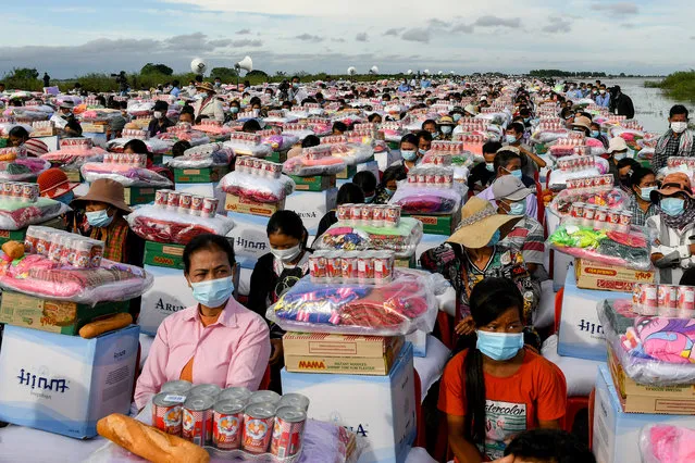 Flood survivors sit next to aid supplies provided by Cambodia's Prime Minister Hun Sen in Banteay Meanchey province on October 21, 2020. (Photo by AFP Photo/Stringer)
