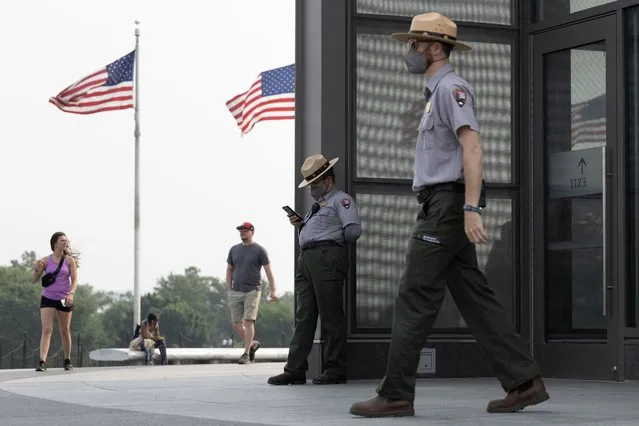 Wearing protective face masks, U.S. Park Rangers stand at the base of the Washington Monument on Wednesday, June 7, 2023. Heavy smoke from Canadian wildfires were visible throughout the region Wednesday. (Photo by Tom Brenner for The Washington Post)