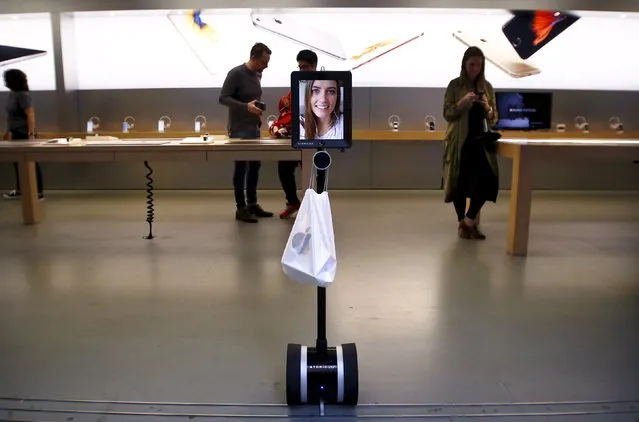 Lucy Kelly is seen on a screen attached to a “telepresence robot”, which she used to purchase her iPhone 6s during the official launch at the Apple store in central Sydney, Australia, September 25, 2015. (Photo by David Gray/Reuters)