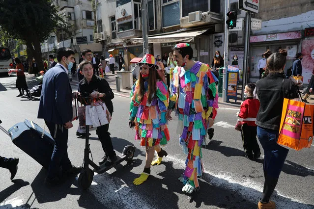 Ultra-Orthodox Jews in costumes made of colorful face masks attend the Purim holiday celebrations in the Orthodox city of Bnei Brak, Israel, 26 February 2021. Although Israel started lifting some of its coronavirus restrictions and allows the use of Green Badge app as vaccination certificate for people who have received two doses of the COVID-19 vaccines, Israel is expected to enforce a night closure during the weekend of Purim celebrations. (Photo by Abir Sultan/EPA/EFE)