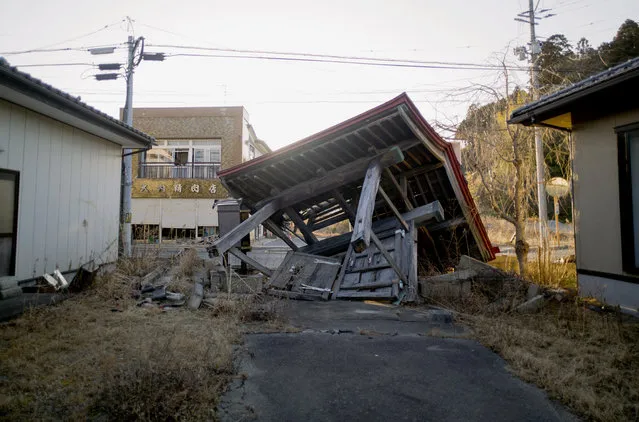 A collapsed gate at a Buddhist temple sits in Futaba town, Fukushima prefecture, northeastern Japan, Sunday, February 28, 2021. The temple is in the area that used to be designated as the nuclear disaster exclusion zone, but the part of the zone has been lifted since March 2020. (Photo by Hiro Komae/AP Photo)