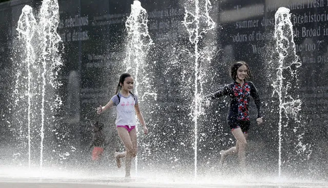 Children play in watersprays at Bicentennial Capitol Mall State Park, Thursday, July 19, 2018, in Nashville, Tenn. (Photo by Mark Humphrey/AP Photo)