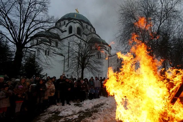 Believers burn dried oak branches, which symbolizes the Yule log, on Orthodox Christmas Eve in front of the St. Sava temple in Belgrade, Serbia, January 6, 2016. Serbian Orthodox believers celebrate Christmas on January 7, according to the Julian calendar. (Photo by Marko Djurica/Reuters)