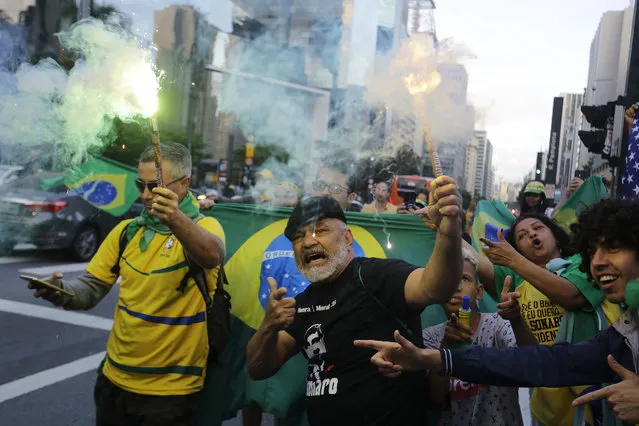 Supporters of Brazilian presidential candidate Jair Bolsonaro cheer as they gather on Paulista Ave. to wait for election runoff results, in Sao Paulo, Brazil, Sunday, October 28, 2018. (Photo by Nelson Antoine/AP Photo)
