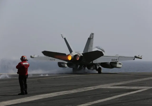 A U.S. military plane takes off from the flight deck of the USS Carl Vinson aircraft carrier in the Persian Gulf, Thursday, March 19, 2015. (Photo by Hasan Jamali/AP Photo)