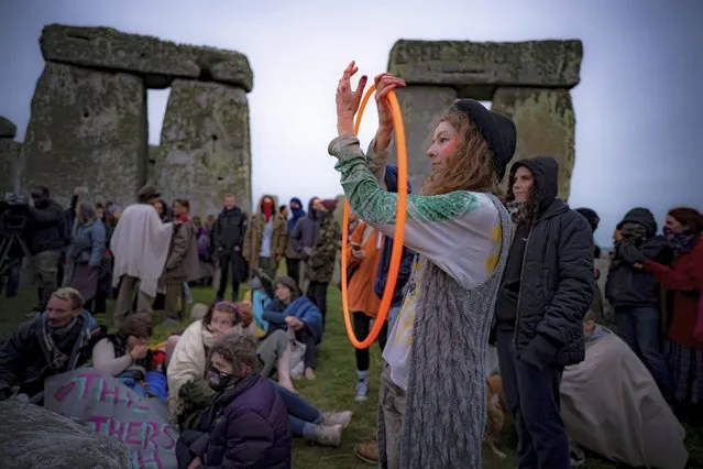 People inside the stone circle during Summer Solstice at Stonehenge, where some people jumped over the fence to enter the stone-circle to watch the sun rise at dawn of the longest day of the year in the UK, in Amesbury, England, Monday June 21, 2021. The prehistoric monument of ancient stones have been officially closed for the celebrations due to the coronavirus lockdown, but groups of people ignored the lockdown to mark the Solstice, watched by low key security. (Photo by Ben Birchall/PA Wire via AP Photo)