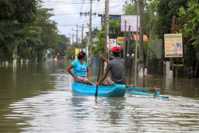 Sri Lankans ride a small boat through a submerged road after heavy rainfall in Kaduwela suburb of Colombo, Sri Lanka, 05 June 2021. (Photo by Chamila Karunarathne/EPA/EFE)