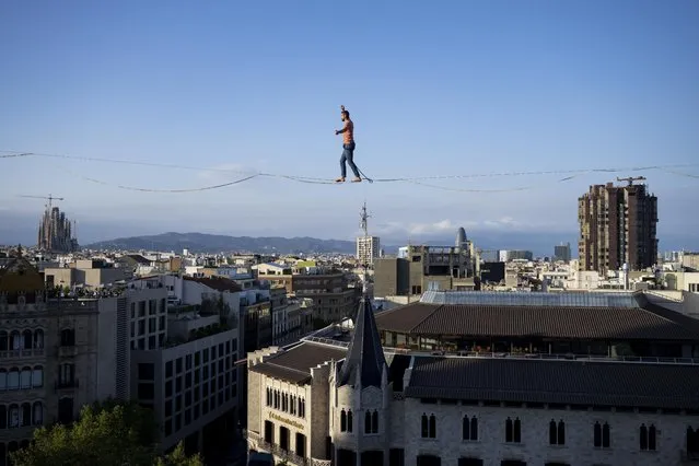 French tightrope walker and artist Nathan Paulin walks on a rope above the Plaza de Catalunya square, as part of the GREC festival in Barcelona, Spain on July 2, 2023. (Photo by Adria Puig/Anadolu Agency via Getty Images)