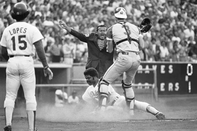 In this July 5, 1978, file photo, home plate umpire Dutch Rennert calls Los Angeles Dodgers' Reggie Smith safe under Atlanta Braves catcher Dale Murphy (3) during the first inning of a baseball game in Los Angeles. Rennert, a National League umpire from 1973 to 1992 who was known for his animated, booming strike calls, has died. He was 88. St. John's Family Funeral Home and Crematory in St. Augustine, Florida, confirmed Monday night, June 18, 2018, that Rennert died on Sunday. A cause of death wasn't given. (Photo by AP Photo/Mclendon)
