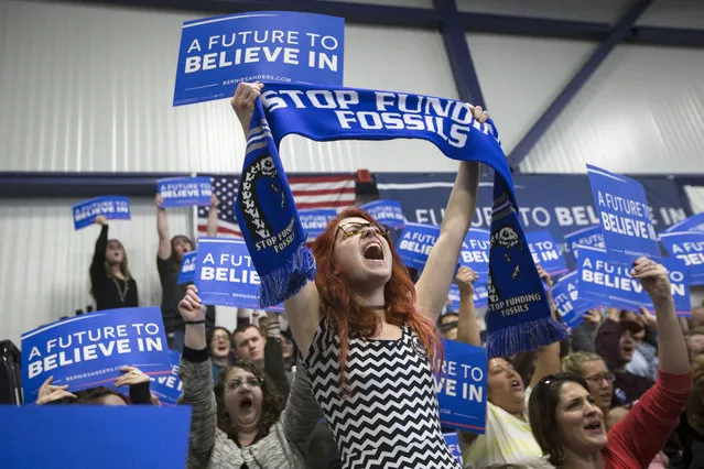 A supporter of Democratic presidential candidate Sen. Bernie Sanders, I-Vt., cheers as he speaks during a campaign stop at Great Bay Community College, Sunday, February 7, 2016, in Portsmouth, N.H. (Photo by John Minchillo/AP Photo)