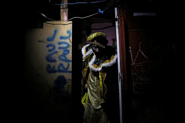 A volunteer of San Carlos Borromeo parish dressed as Balthasar, one of the Three Wise Men gives away gifts in the shanty town settlement of “El Gallinero”, in the outskirts of Madrid, Spain, January 6, 2017. (Photo by Juan Medina/Reuters)