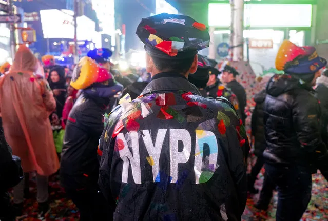 A New York City police officer is covered with confetti in Times Square in New York, Tuesday, January 1, 2019, as people take part in the New Year's celebration. (Photo by Craig Ruttle/AP Photo)