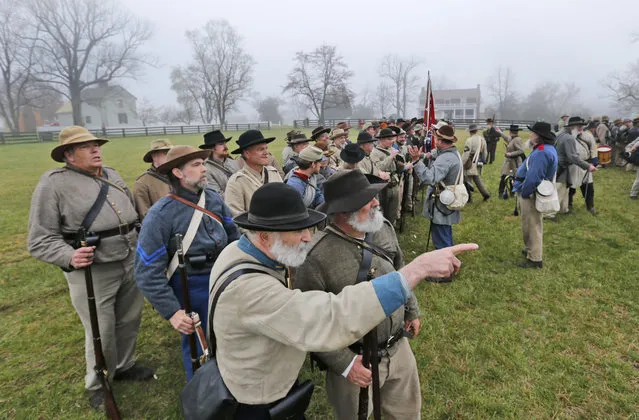 Confederate troops muster in front of the McLean House as they prepare for battle during a re-enactment of the Battle of Appomattox Courthouse as part of  commemoration of the 150th anniversary of the surrender of the Army of Northern Virginia at Appomattox Court House in Appomattox, Va., Thursday, April 9, 2015. (Photo by Steve Helber/AP Photo)