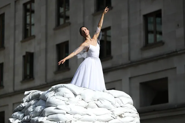 Christine Shevchenko, a Ukrainian-American dancer from Odessa, performs on top of a sandbag art installation entitled 'Defiant Dancer' as a symbol of support towards Ukraine's enduring art and culture scene in Covent Garden, London on Thursday, September 8, 2022. In Ukraine, statues and cultural monuments are entombed in sandbags to ensure their survival against the missiles and bombs of war. (Photo by Kieran Cleeves/PA Wire)