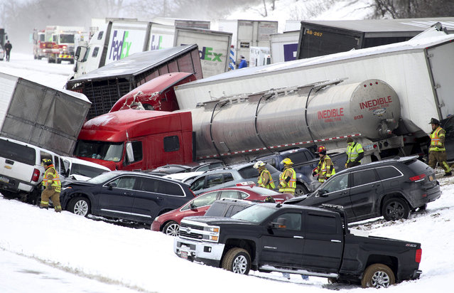 Emergency personnel work at the scene of a fatal crash near Fredericksburg, Pa., Saturday, February 13, 2016. The pileup left tractor-trailers, box trucks and cars tangled together across several lanes of traffic and into the snow-covered median. (Photo by Daniel Zampogna/PennLive.com via AP Photo)