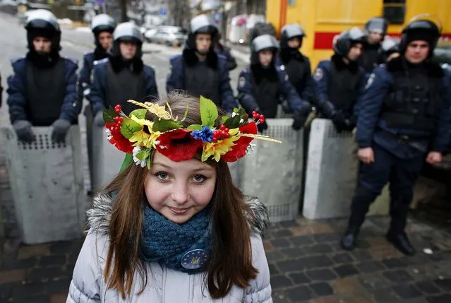 A young Pro-European integration protester stands in front of police during a mass rally at Independence Square in Kiev, on December 15, 2013. Thousands of Ukrainian massed on Sunday for a rally against President Viktor Yanukovich just days before he heads for a meeting in the Kremlin which the opposition fears will slam the door on integration with the European mainstream. (Photo by Marko Djurica/Reuters)